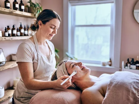 Esthetician applying a facial treatment to a client at a spa